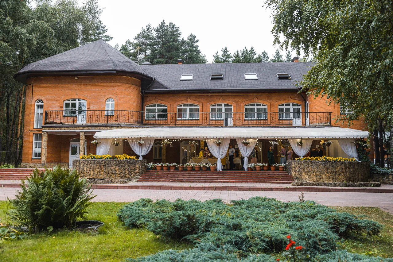 Главный корпус загородного клуба «Бисерово» с банкетным шатром во время свадьбы
